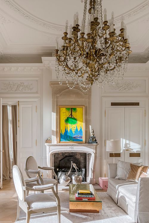 Grand salon haussmannien dans un immeuble de 1880 à la Place de l’Etoile, Paris, avec cheminée blanche, lustre en cristal et moulures au plafond. Photographie d’architecture intérieure par Nicolas Karadimos.