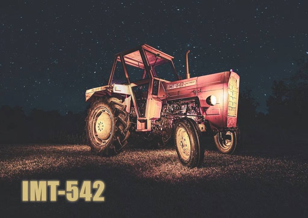 Ein alter Traktor des Modells IMT 542 bei Nacht, kunstvoll beleuchtet durch Lichtmalerei (Light Painting) unter einem Sternenhimmel auf einer Wiese