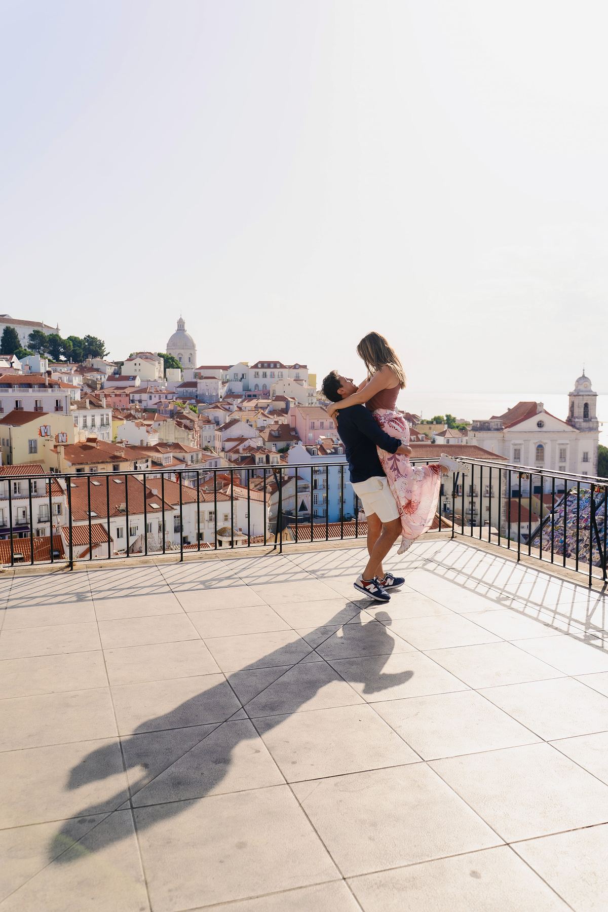 Man lifting his partner after their surprise proposal in Alfama