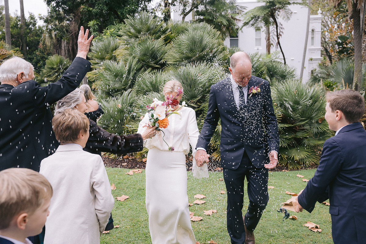Guests tossing rice towards the newlyweds at an intimate wedding ceremony at Chiswick Woollahra.