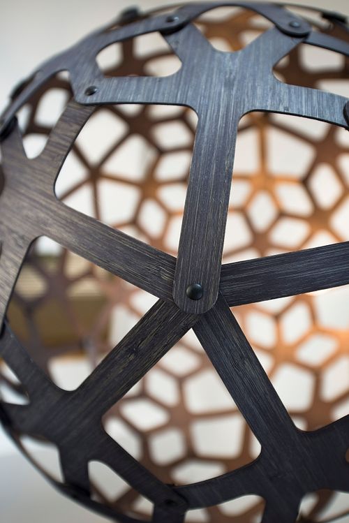 Détail d’une structure géométrique sphérique en métal noir avec motifs ajourés. Photographie d’architecture et de design intérieur par Nicolas Karadimos.
