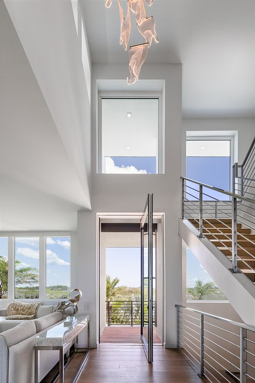 Architectural interior photography of a luxury beachfront master bedroom in Ponte Vedra Beach, Florida, featuring high ceilings, coastal design elements, and large windows with Atlantic Ocean views.