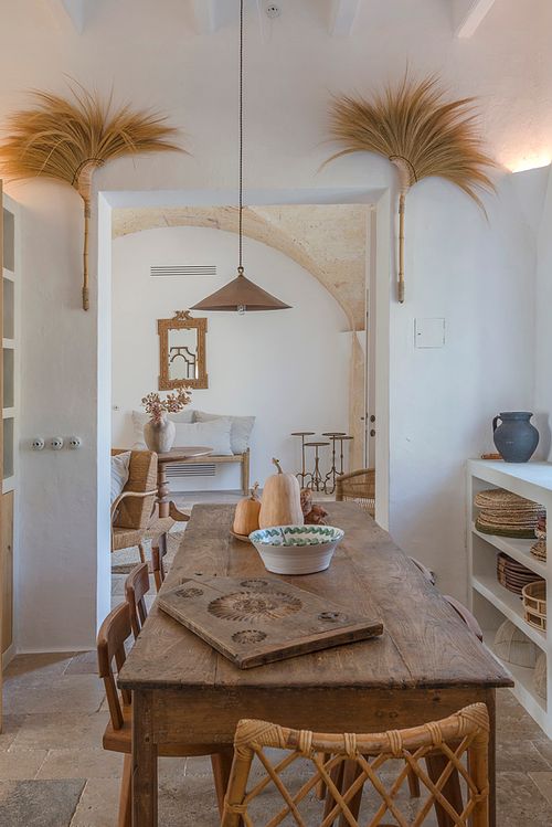 Salle à manger de la finca d’agrotourisme à Santa Ponça, Minorque, avec table en bois et chaises en rotin. Photographie par Nicolas Karadimos.