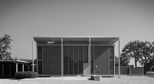 Monochrome perspective of the landmark Umbrella House in Sarasota, Florida, designed by Paul Rudolph, emphasizing the play of bright sunlight and deep shadows across its minimalist facade.