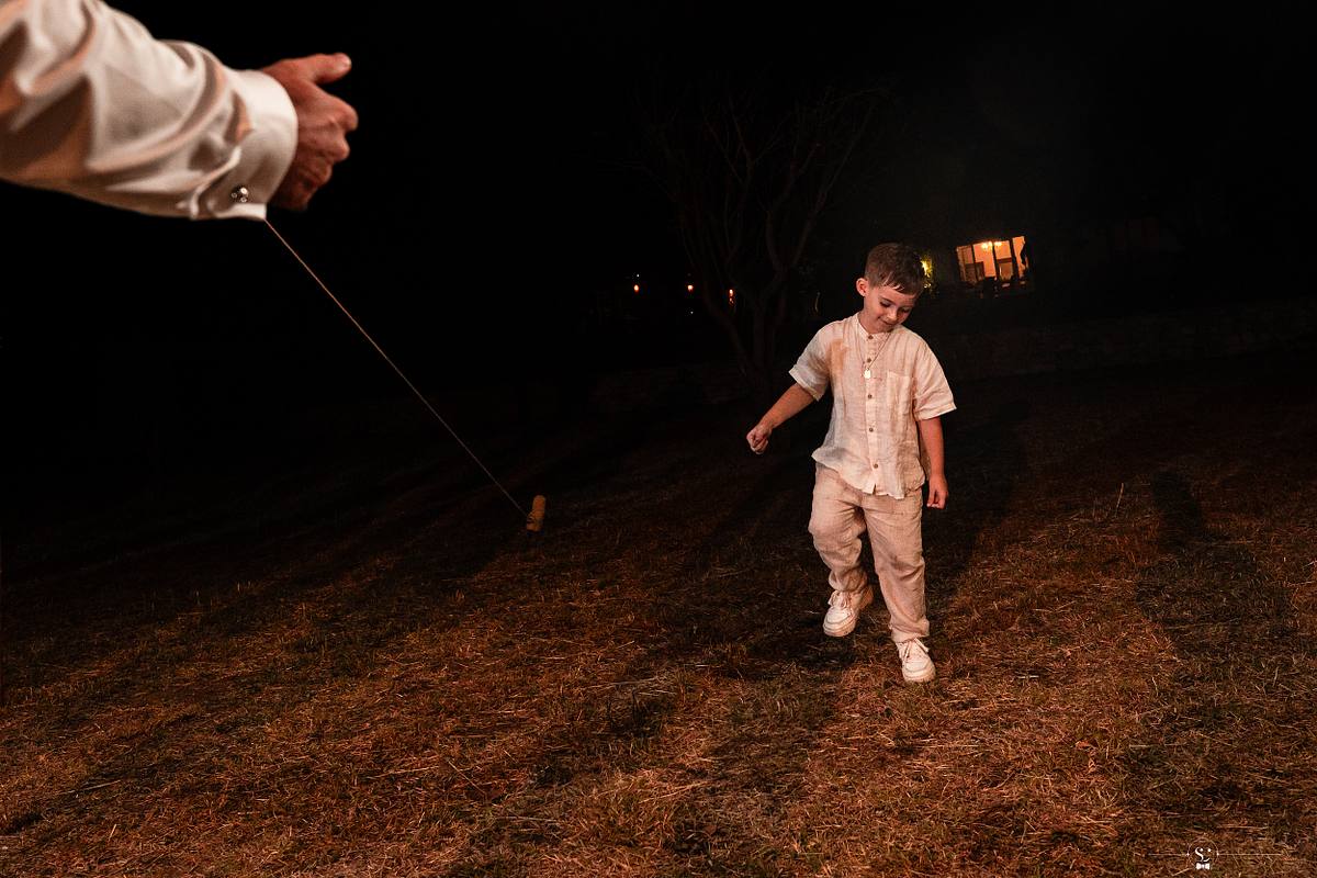 Fils des mari&eacute;s dansant sur l'herbe la nuit, une sc&egrave;ne captur&eacute;e par S&eacute;bastien Clavel, photographe de mariage