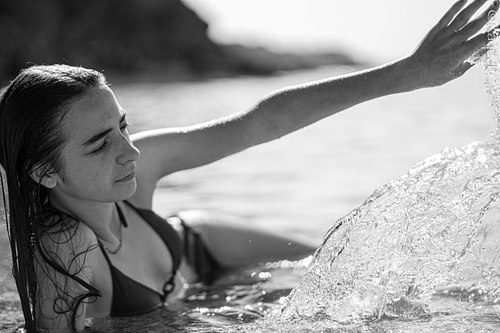 Jeune femme jouant avec l’eau en noir et blanc.