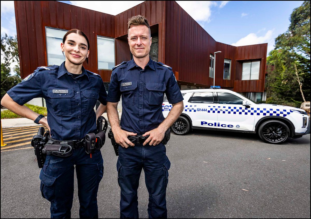 Portrait of two police officers outside Somerville Police complex.