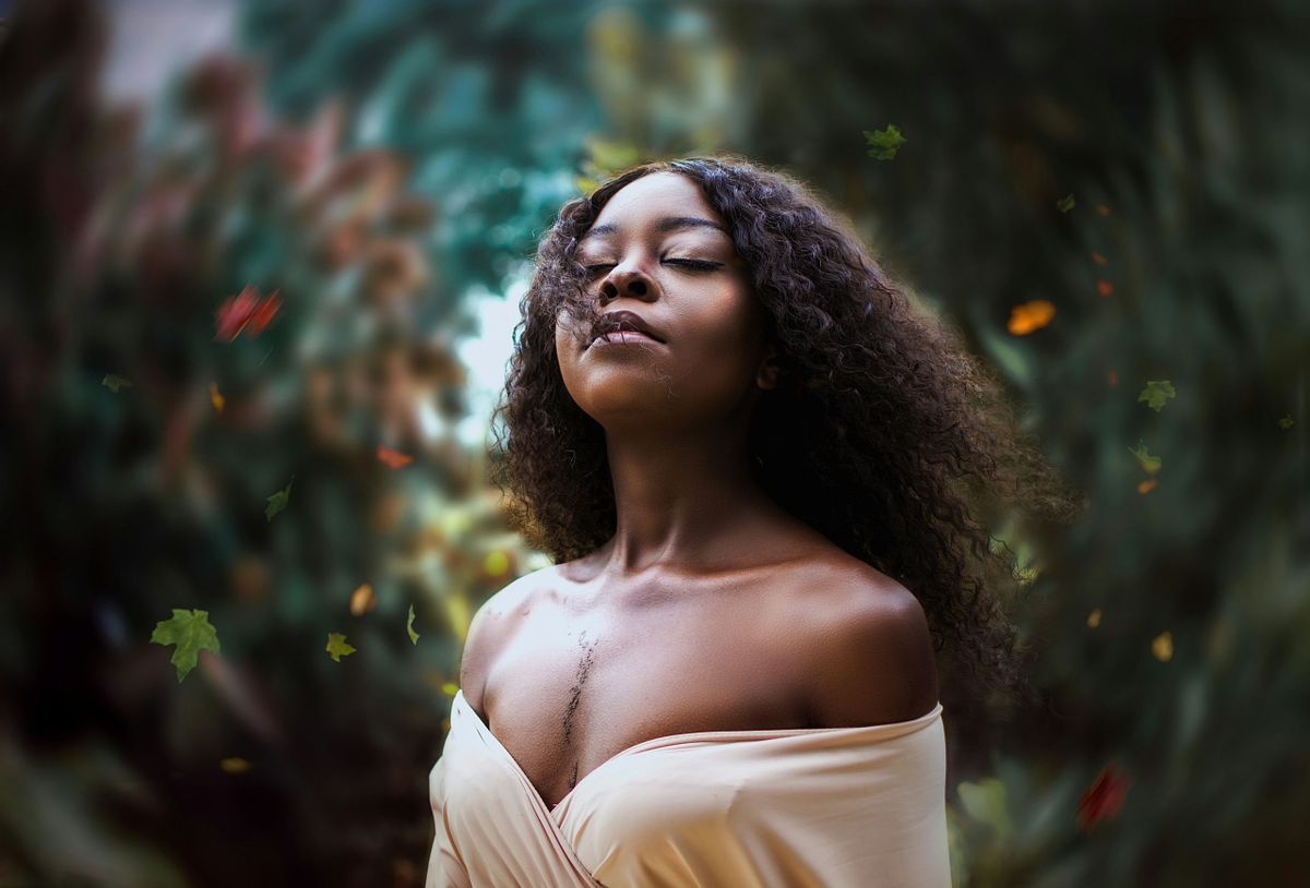 High school senior posing confidently outdoors in natural light.