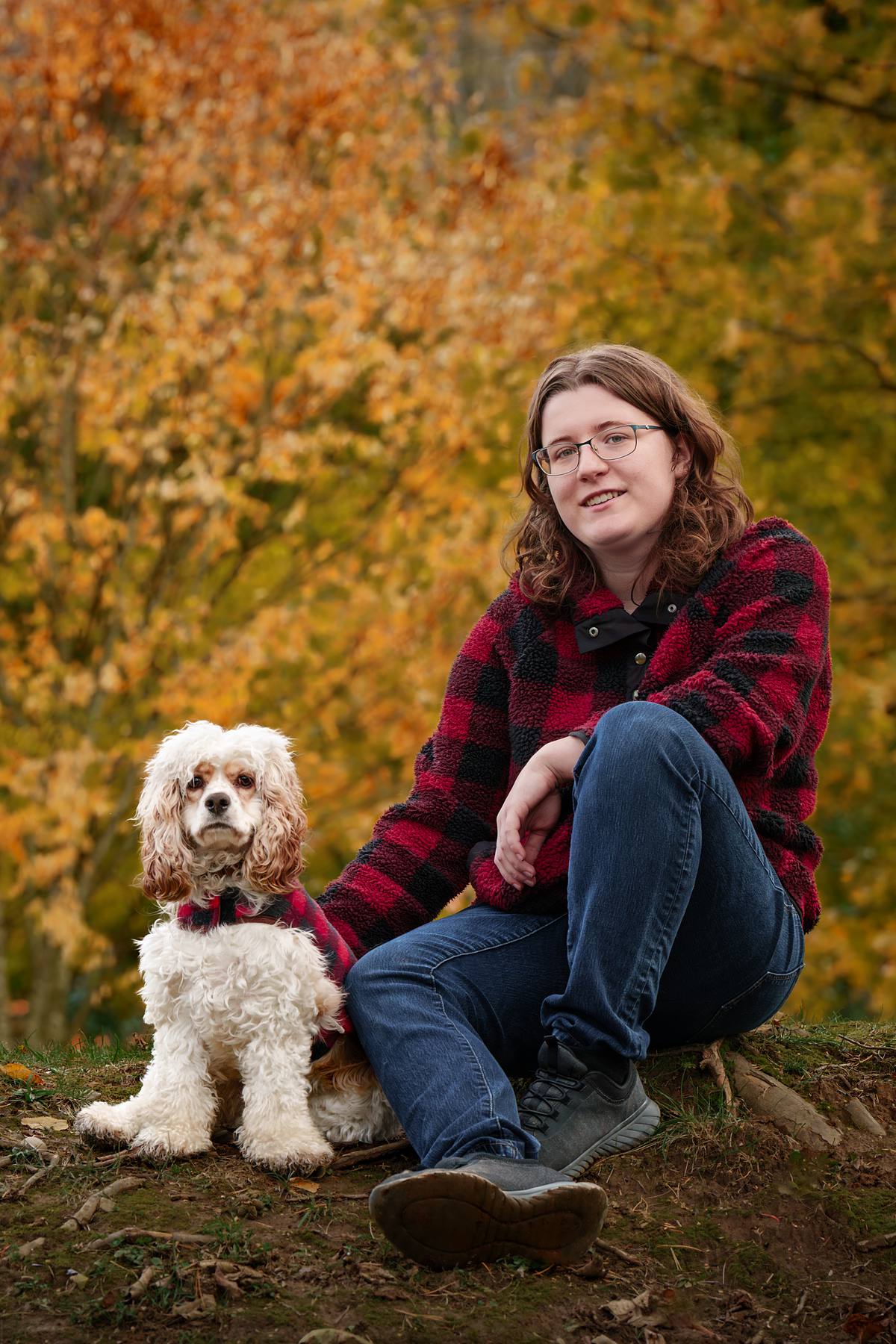 Woman and her cocker spaniel at the park on a fall day.