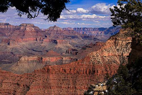 A wide-angle horizontal fine art photograph of the Grand Canyon from the South Rim, showcasing the layered red rock buttes and deep shadows carved into the canyon walls.