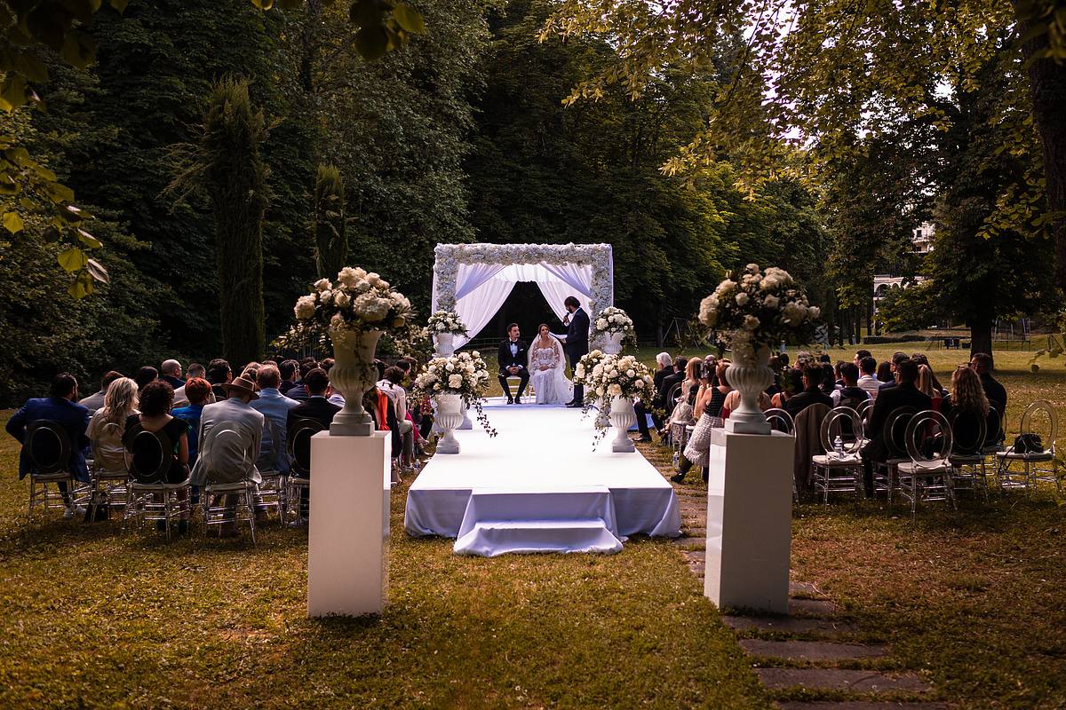 Un couple de jeunes mari&eacute;s partage un moment tendre sous la Houppa dans un cadre verdoyant, captur&eacute; par Sebastien Clavel, photographe de mariage &agrave; Lyon, &agrave; l'Hotel Pavillon