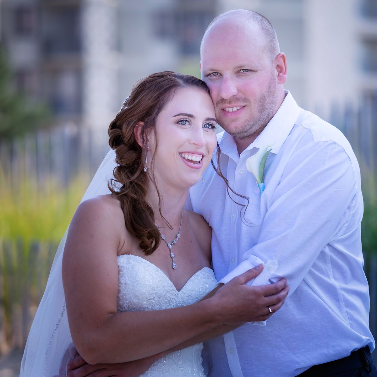 first look at a summer wedding during, the bride and groom are hugging each other,
