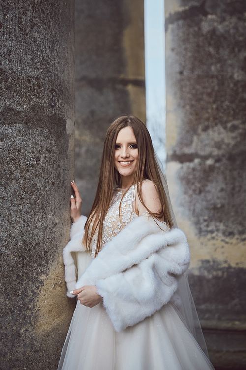 Bride standing beside the columns at St. Joseph’s Church, Pidhirtsi