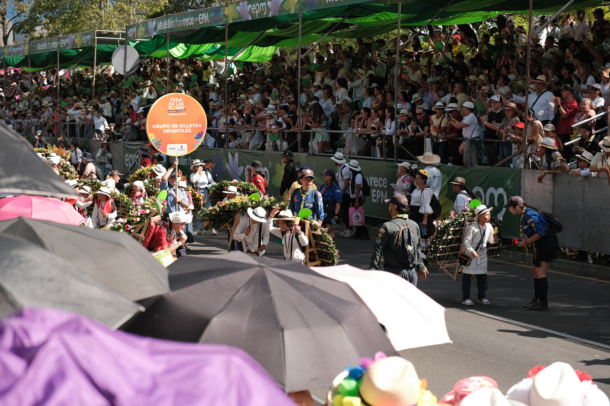 Silleteros cargando sus silletas por la ruta del desfile ante el público en Medellín