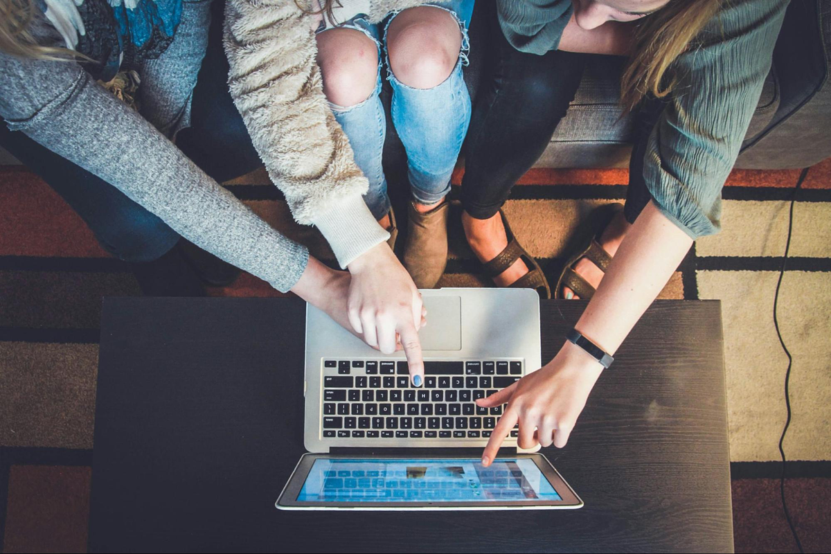 3 Personen schauen auf einen Laptop-Bildschirm
