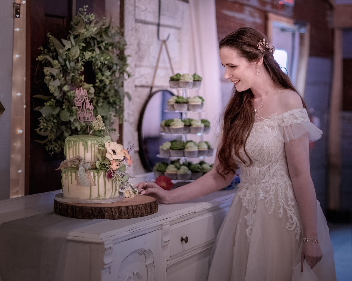 the bride is looking at the cake before the ceremony at chickberry farm, laurel, de by windsweptphotodesign
