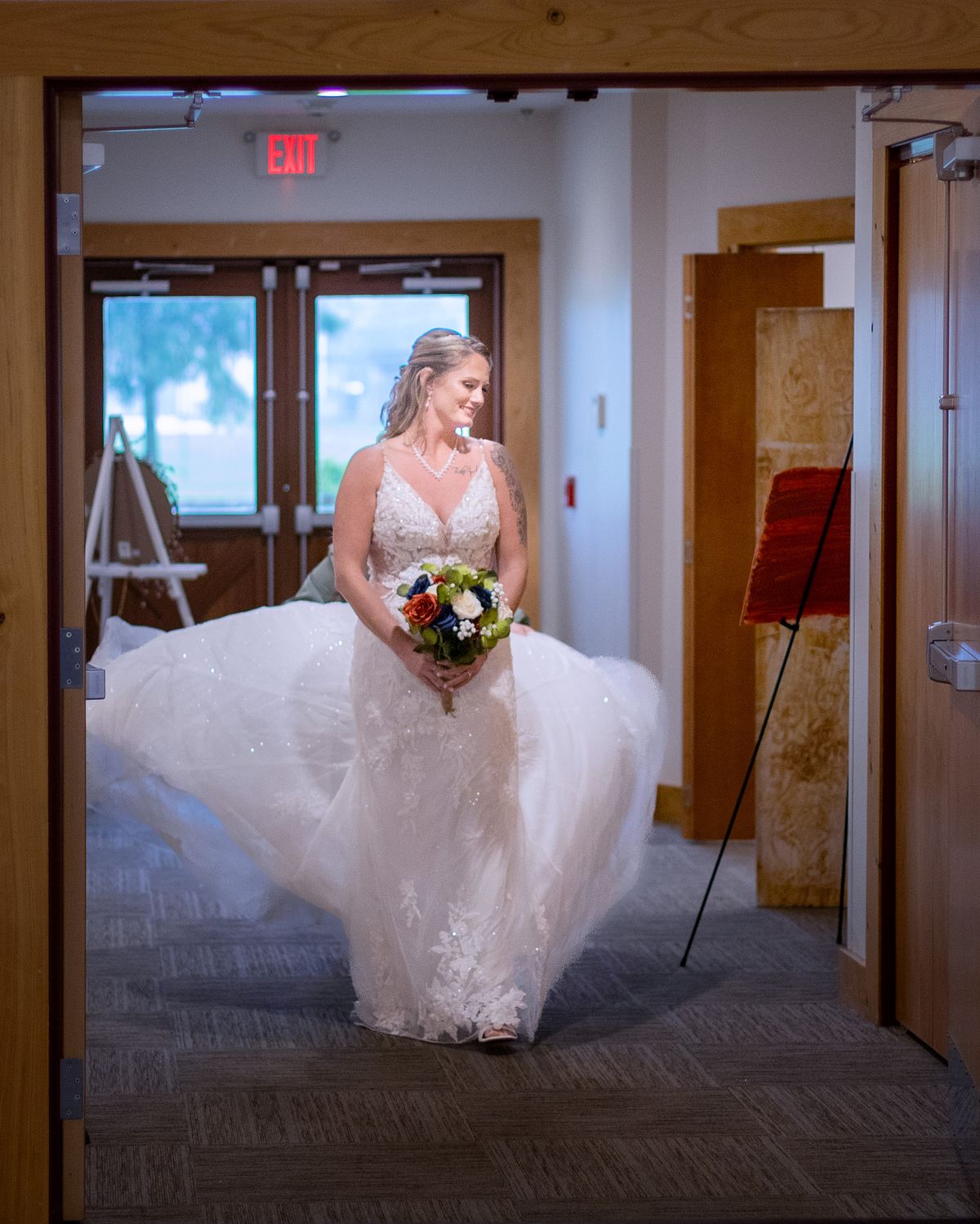 entrance of the bride, with her train fluffed up for dramatic effect, she is holding her flowers and looking to the side