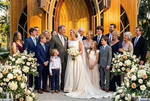 A joyful mature bride and groom celebrating their second marriage surrounded by their wedding party and guests in an elegant Florida setting.
