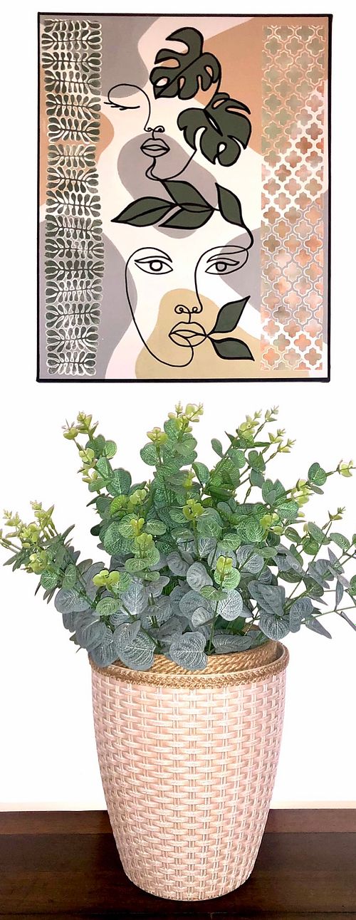 Potted plant with greenery and modern artwork featuring a face design, perfect for home decor