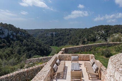 Terrasse avec vue panoramique sur la vallée et les falaises depuis la finca Son Fonoll à Minorque. Photographie par Nicolas Karadimos.