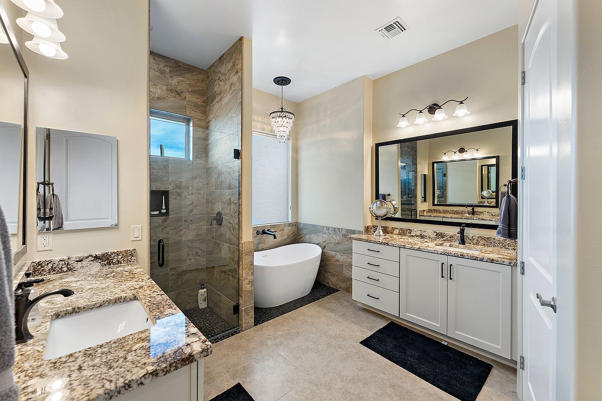 Bright and luxurious bathroom with chandeliers and freestanding tub in Broomfield CO