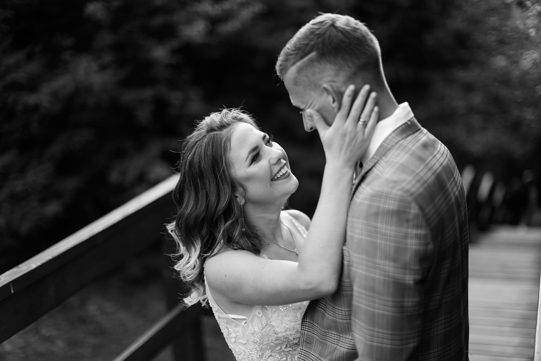 Bride and groom sharing a quiet moment on a wooden bridge