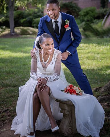 a couple sitting in the park, the bride is sitting on a concrete bench as the sun set in spring