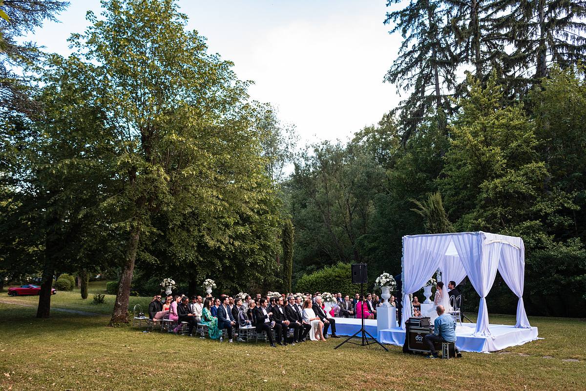 Vue panoramique sur la c&eacute;r&eacute;monie de mariage en plein air, invit&eacute;s captiv&eacute;s par l'union au Pavillon Casino Lyon Vert