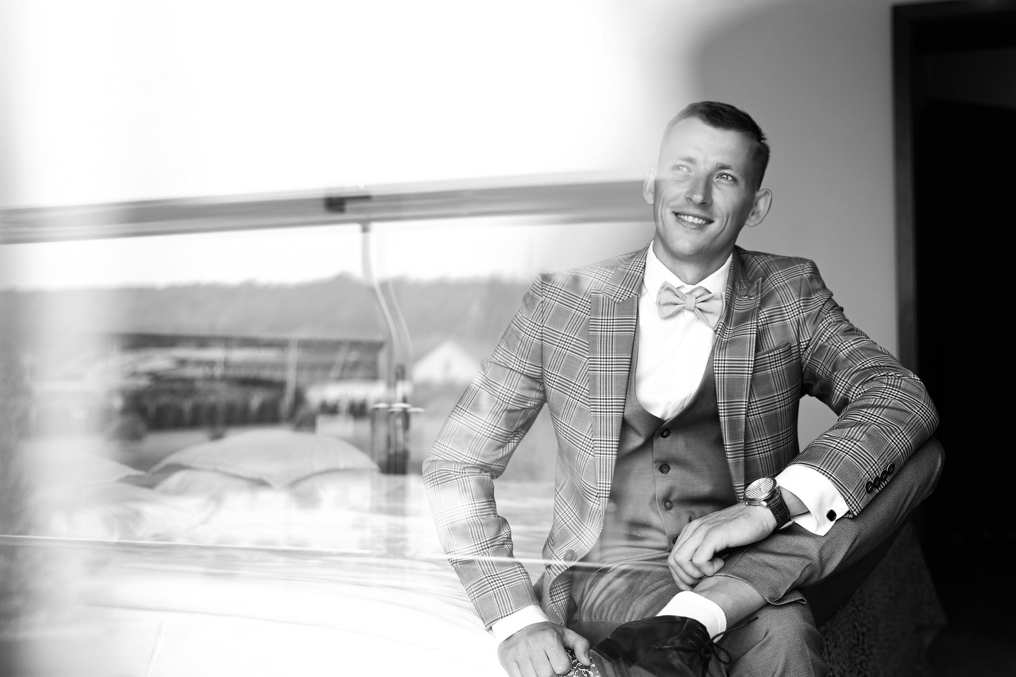 Black and white bridal portrait by the window before the wedding ceremony