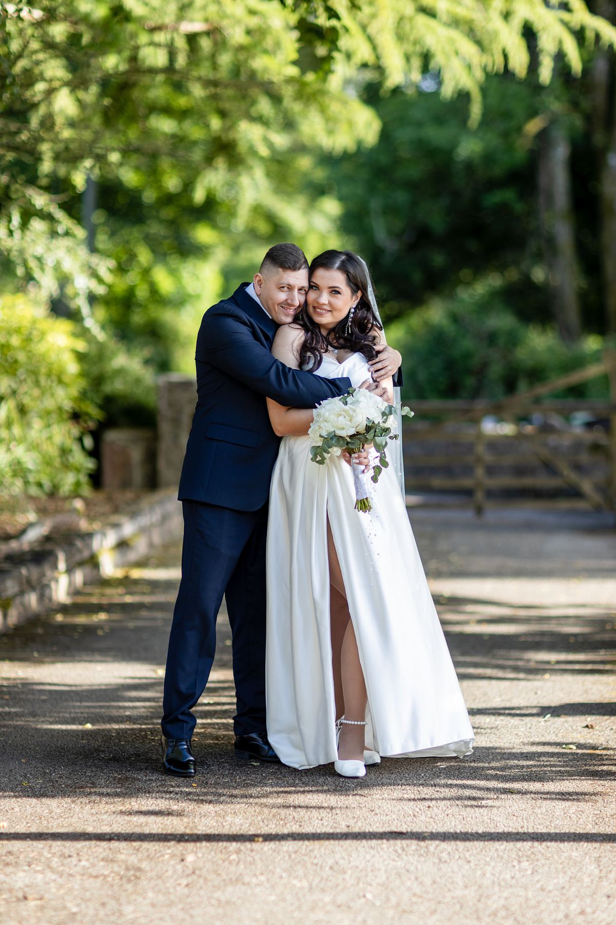 Full-length portrait of bride and groom embracing outdoors in South Wales, photographed by Marta Vershynina South Wales wedding photographer