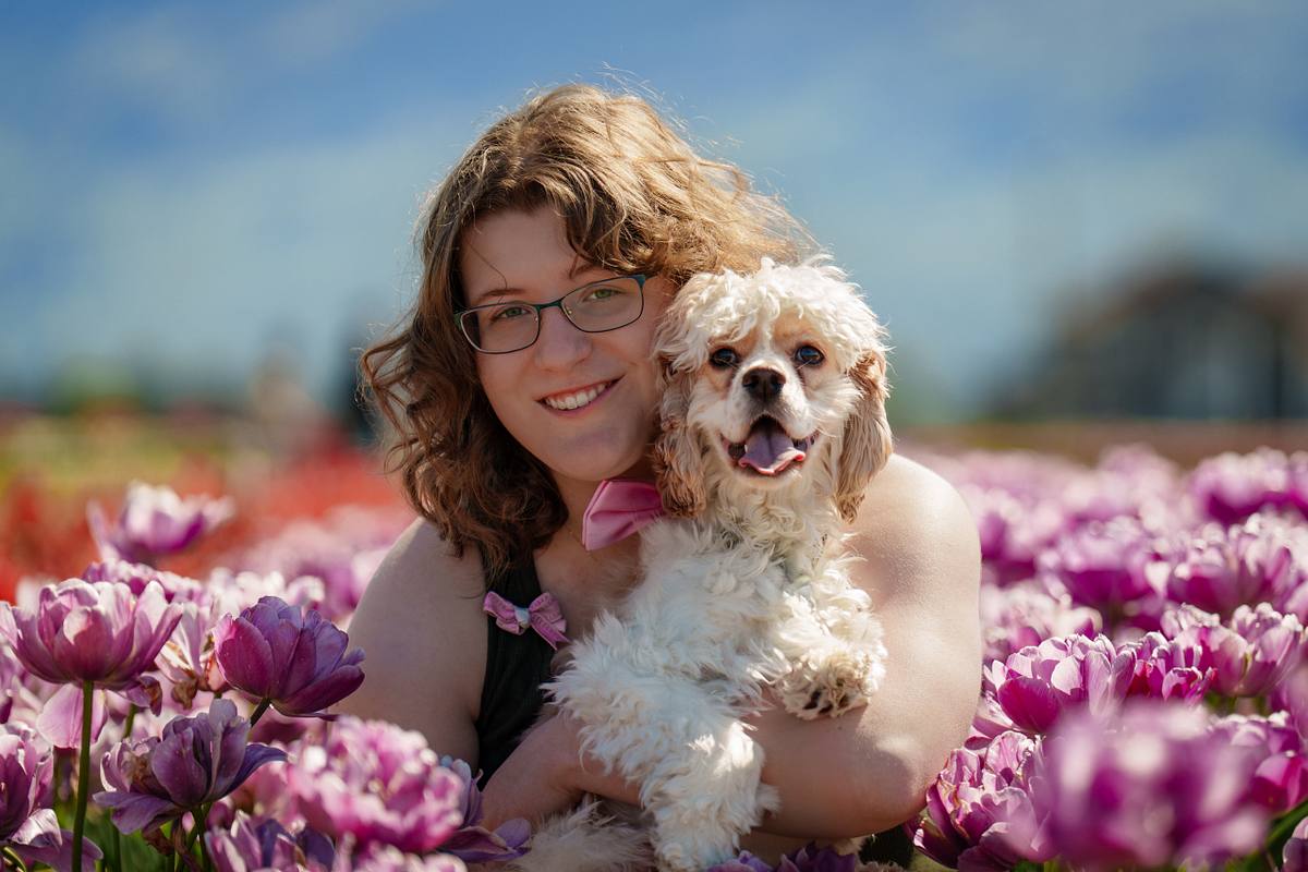 Woman with her cocker spaniel in a pink tulip field.