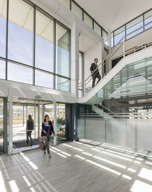 Interior architectural photography of the Florida Public Utilities headquarters lobby in Yulee, Florida, featuring a modern multi-level lobby with glass railings and natural light.