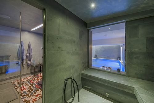 Espace bien-être avec piscine intérieure et mur en béton dans un appartement haussmannien sur les Champs-Élysées, Paris. Photographie d’architecture intérieure par Nicolas Karadimos.