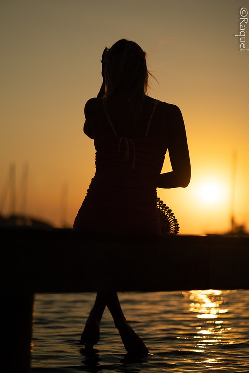 Portrait lifestyle d’une femme assise en bord de mer au coucher du soleil à Hyères