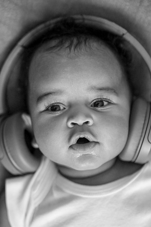 Portrait en noir et blanc d’un bébé portant un casque audio.