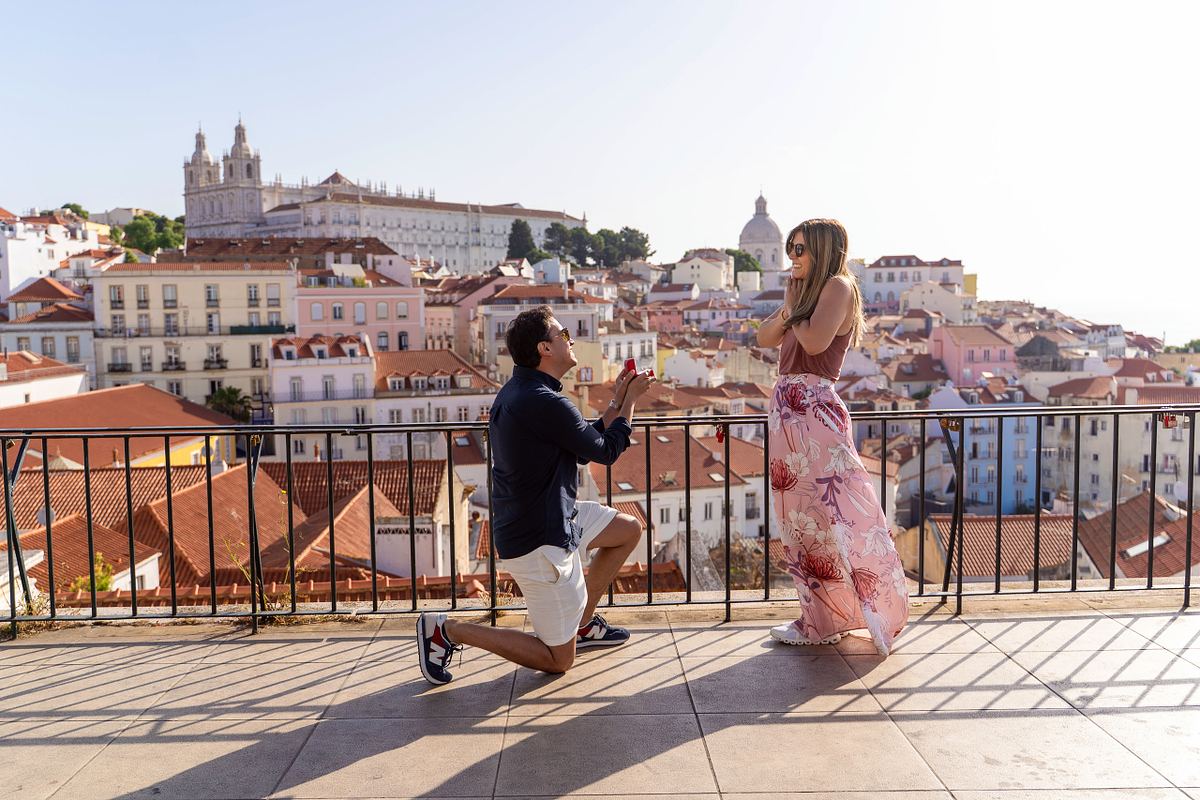 Man proposing at a scenic Lisbon viewpoint overlooking Alfama