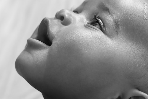 Gros plan en noir et blanc du visage d’un bébé.