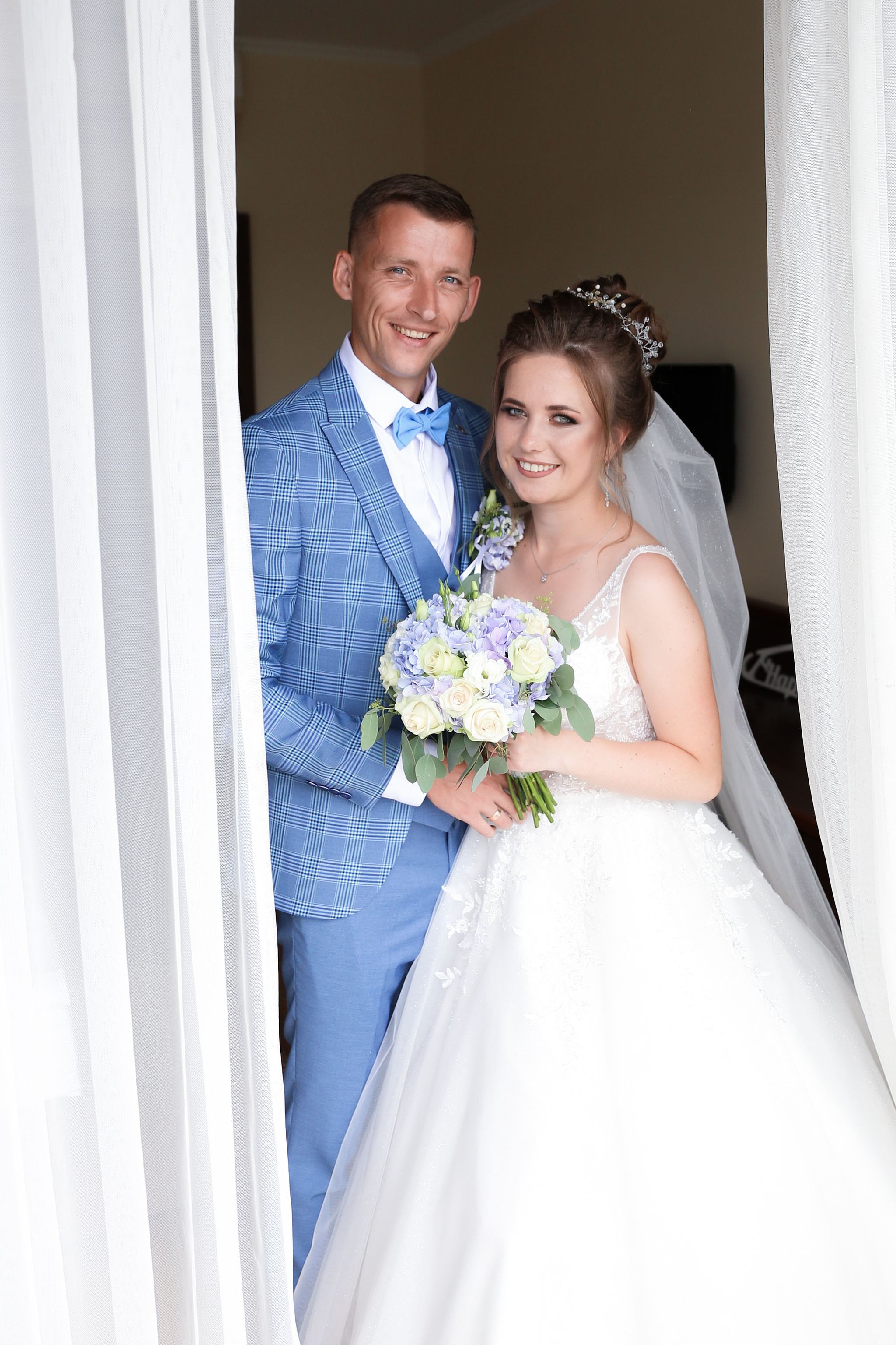 Bride and groom wedding portrait with blue and white flowers in Ukraine