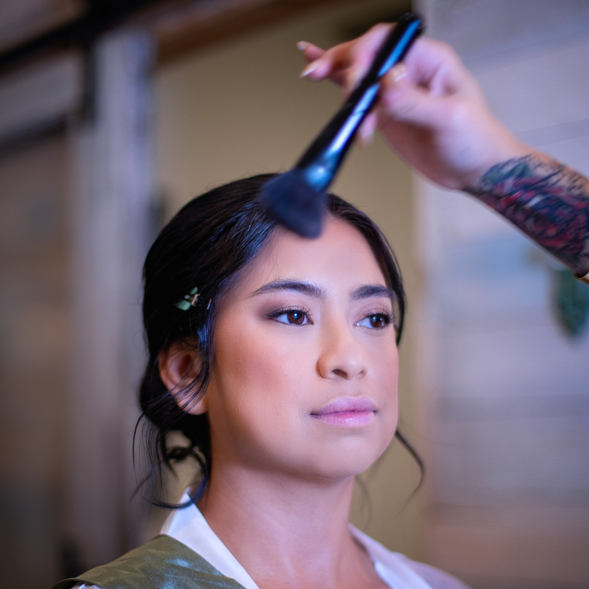 make-up artist adding finishing powder at Kylan Barn's bridal suite, while the bride is looking in the mirror