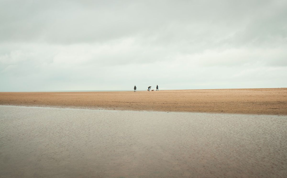 Wide sandy beach at Holkham, Norfolk, with a calm, minimalist coastal landscape.
