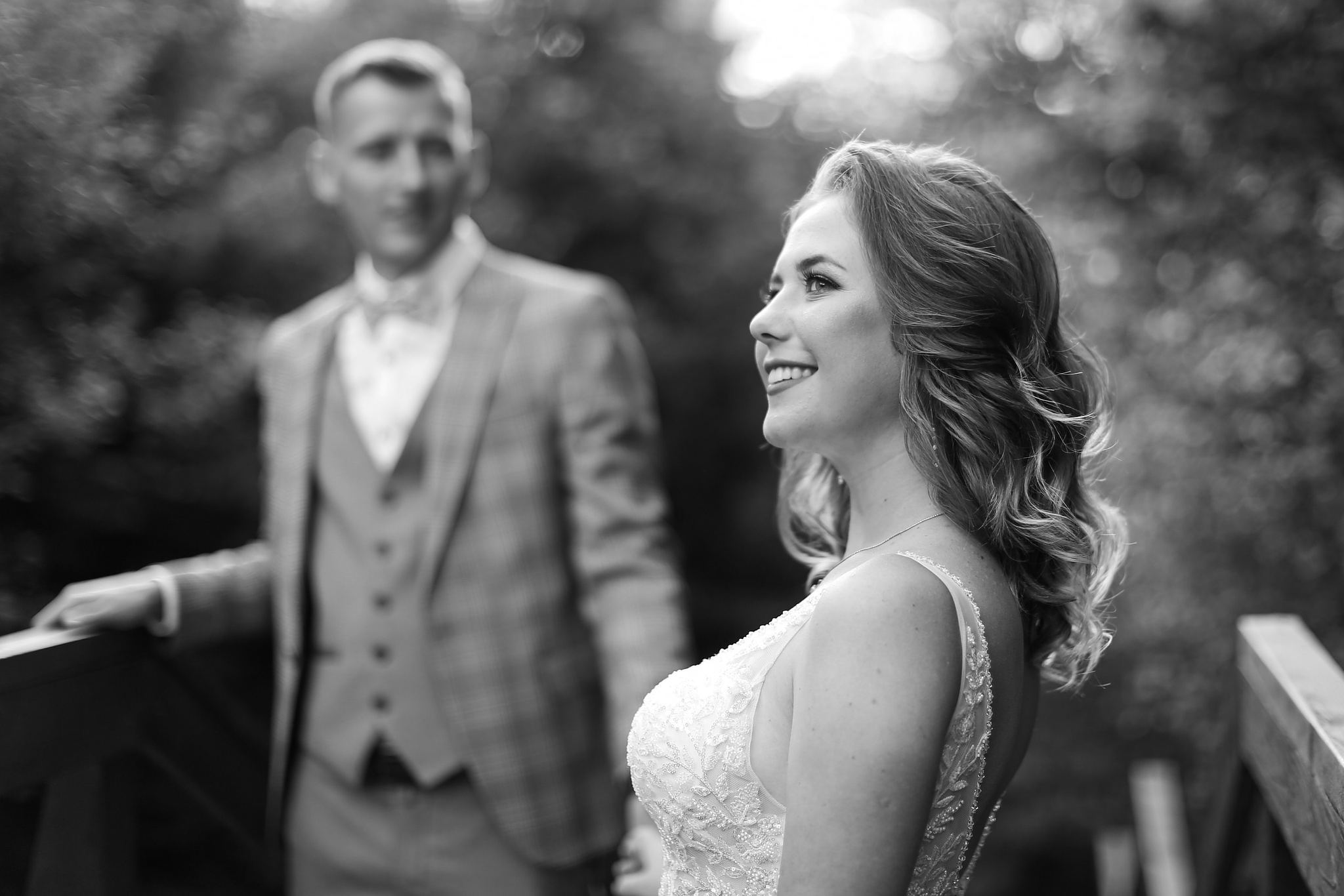 Bride and groom sharing a quiet moment on a wooden bridge