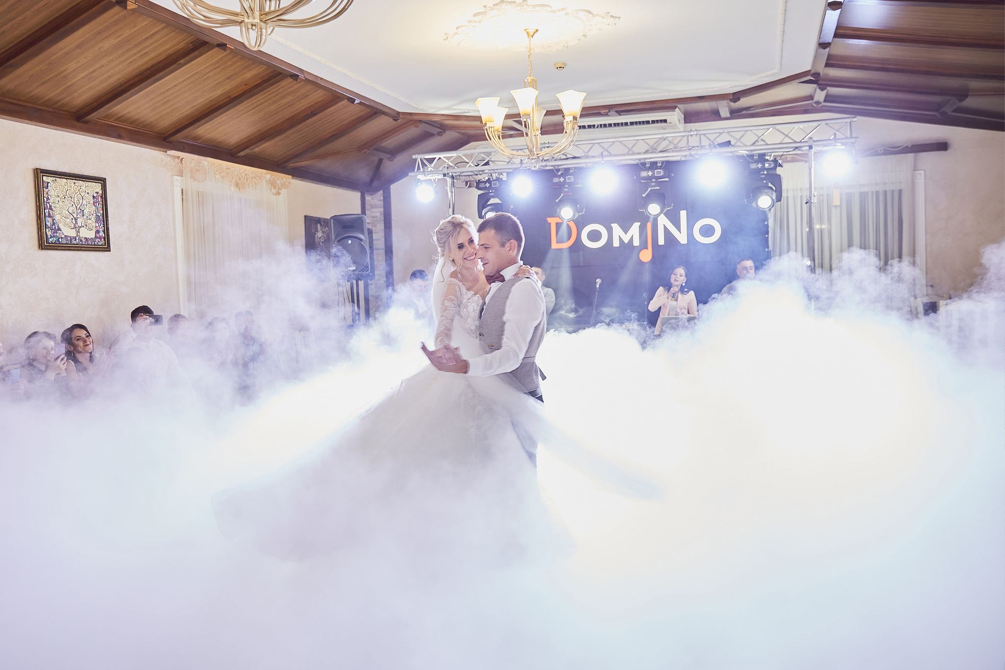 Bride and groom dancing together surrounded by low-lying fog