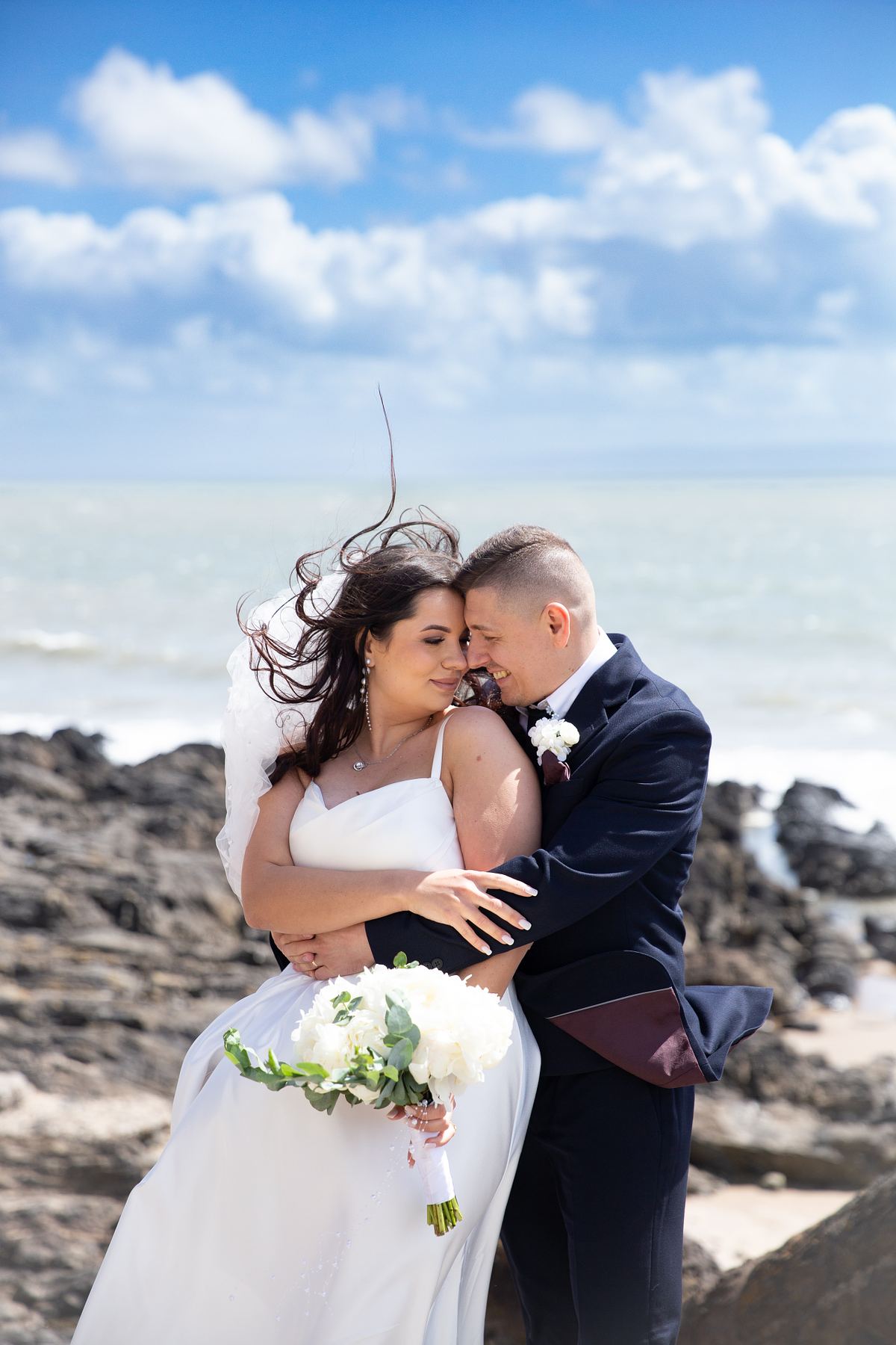 Close portrait of bride and groom embracing by the sea at Barry Island, photographed by Marta Vershynina South Wales wedding photographer