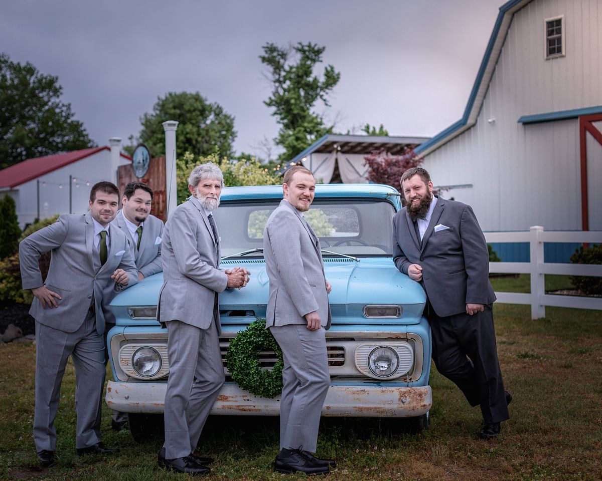 groom and groomsmen posing in front of an antique car at chickberry farm in laurel, delaware