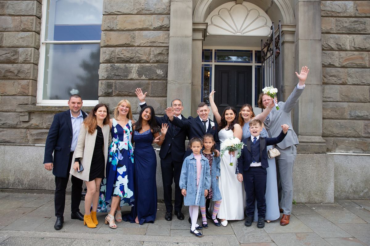 Wedding guests with bride and groom outside Pontypool Register Office, South Wales