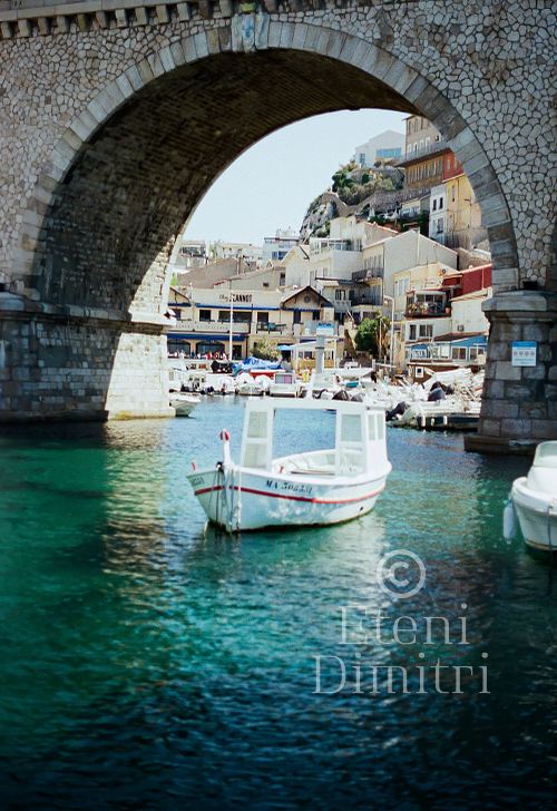 Photographie argentique d’un bateau dans le Vallon des Auffes à Marseille, encadré par l’arche du pont, par Dimitri Eteni