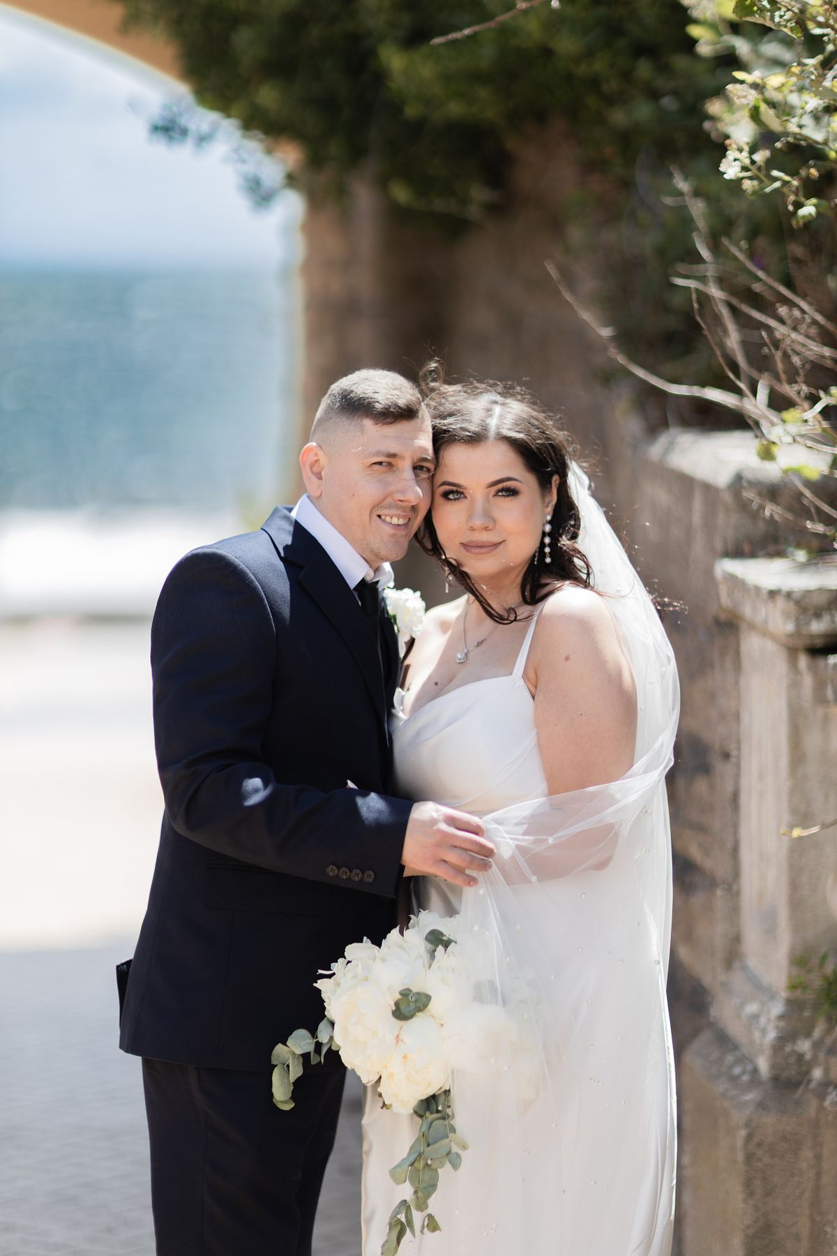 Close portrait of bride and groom beside the seafront at Barry Island, South Wales