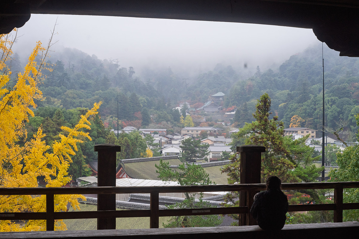 Vue depuis le pavillon Senjōkaku sur le village de Miyajima et les montagnes dans la brume, un jour de pluie