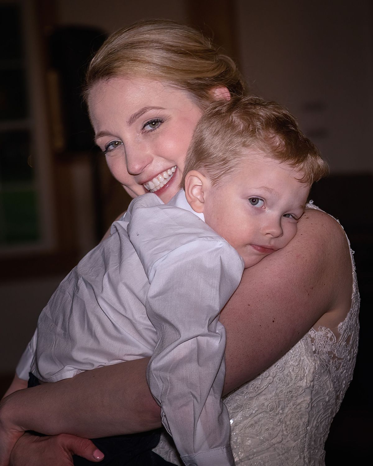 intimate photo of bride holding her sleepy son at the reception