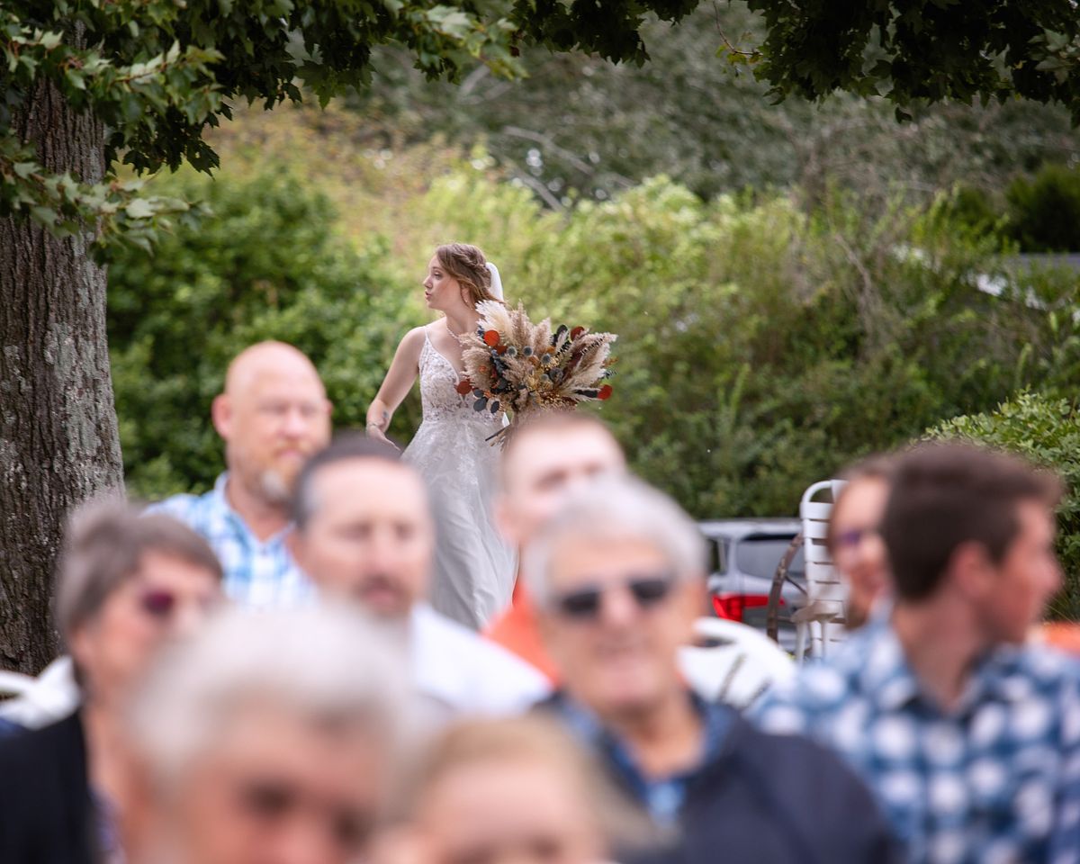 candid of bride before walking down the aisle with guests in the foreground at a farmstead wedding in Harrington, DE